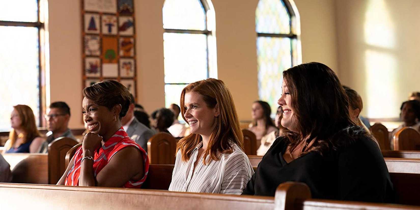 Heather Headley, JoAnna Garcia Swisher, and Brooke Elliott laugh while sitting in church in Sweet Magnolias Season 1 on Netflix