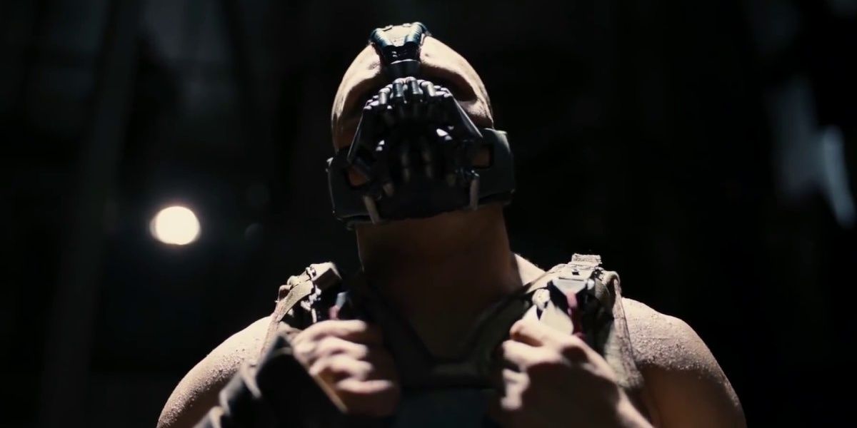 Bane segurando seu melhor e parecendo desafiador em The Dark Knight Rises