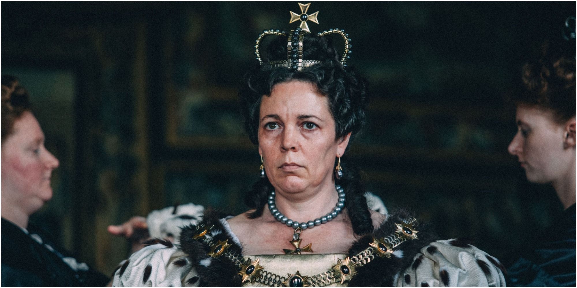 Olvia Coleman stares while dressed in royal garb in The Favourite.