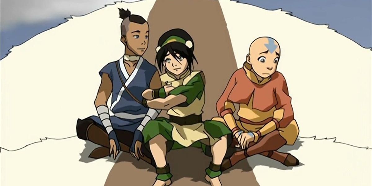 Toph holding Sokka's arm as they and Aang sit on Appa