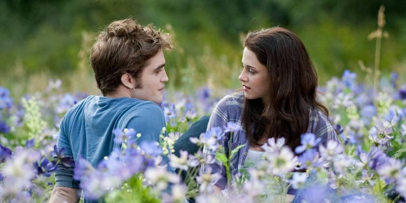 Edward and Bella sitting in a field of flowers in Twilight