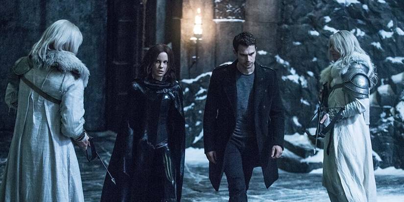 Selene (Kate Beckinsale) walks past guards in the snow in Underworld: Blood Wars.