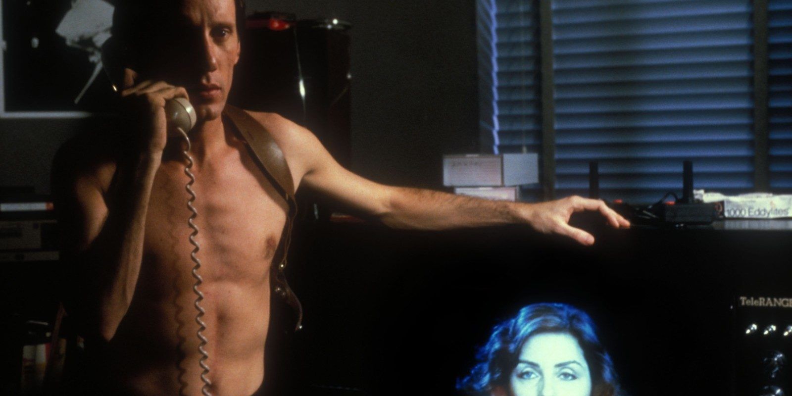 A topless man on the phone in Videodrome