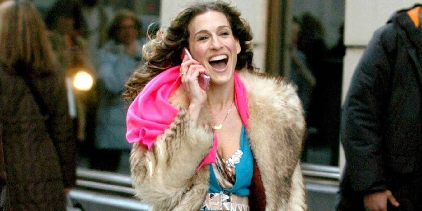 Carrie smiling while walking and talking on her phone in Sex and the City