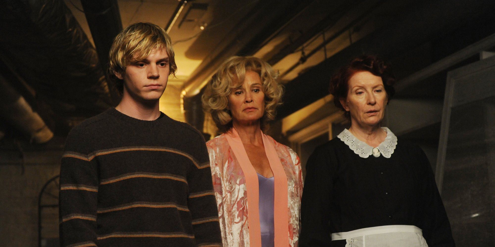 Tate, Constance, and Moira look at something in American Horror Story