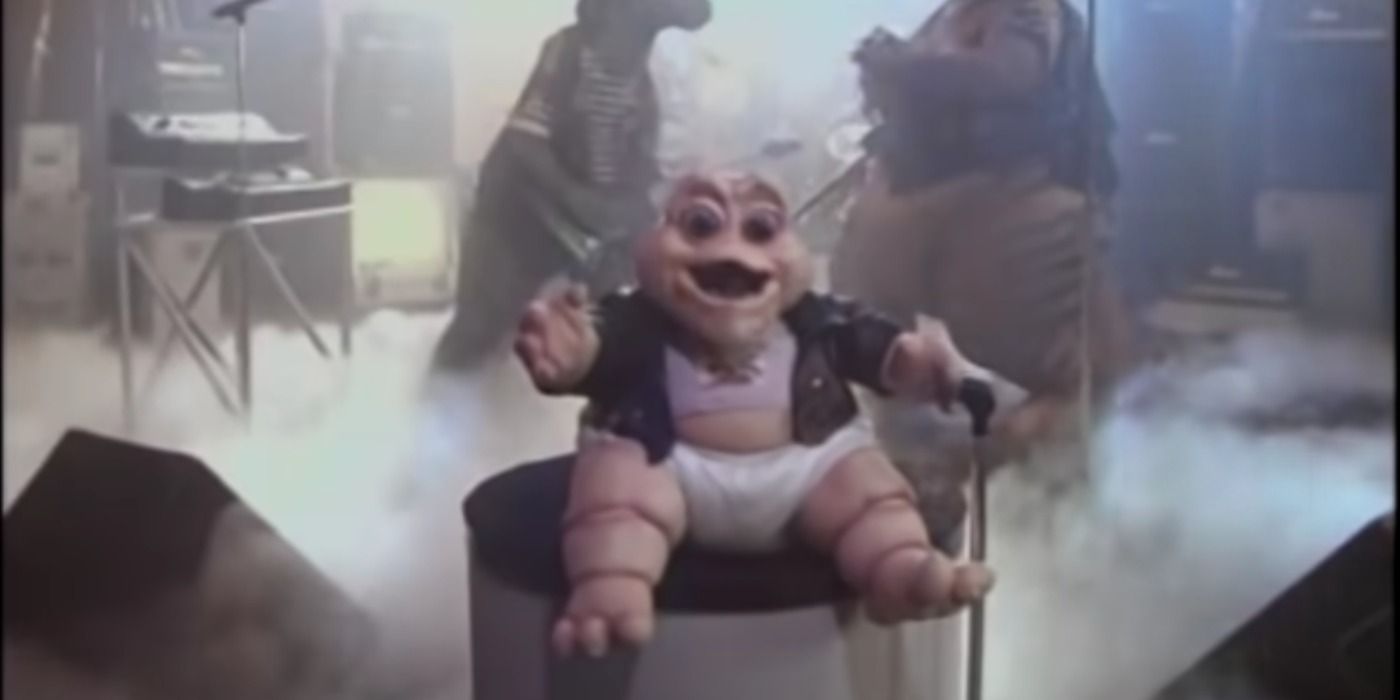 Baby Sinclear from Dinosaurs performing in a leather jacket for a music video.