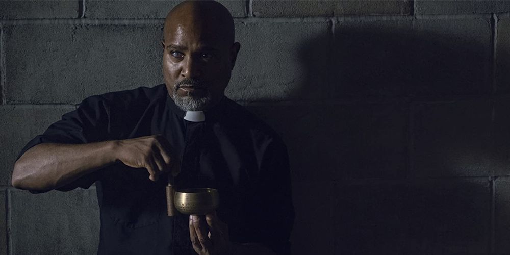 Father Gabriel holding a cup in The Walking Dead