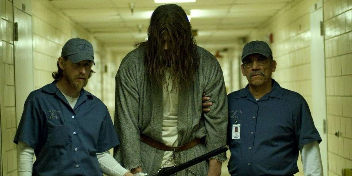 Guards hold a handcuffed Michael Myers