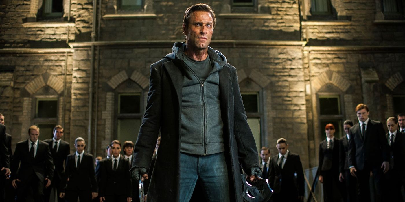 Aaron Eckhart standing in front of a building and crowd in I Frankenstein