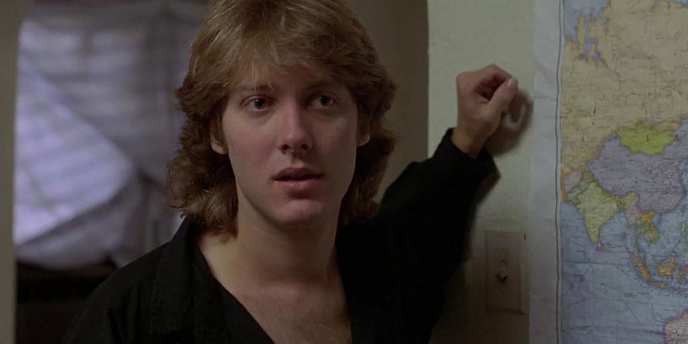 James Spader in a scene from Sex, Lies & Videotape, standing by a world map on the floor, hand beside it looking at someone longingly.