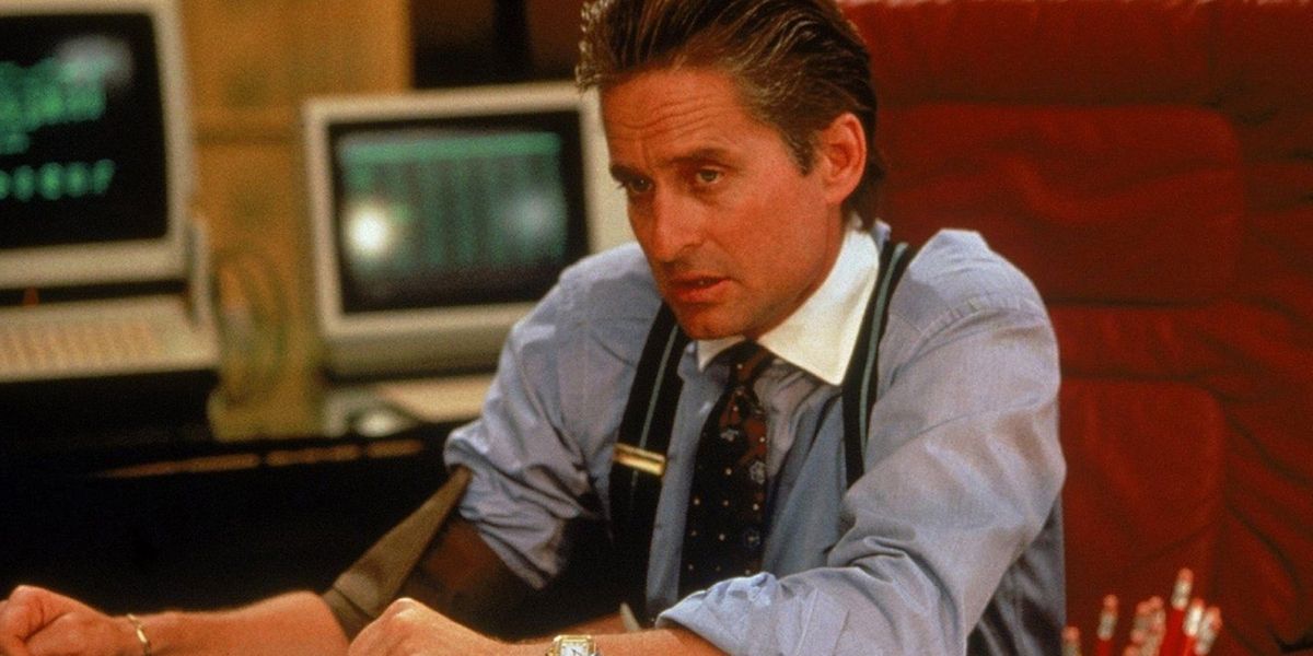 Michael Douglas as Gordon Gekko sitting at his desk in Wall Street