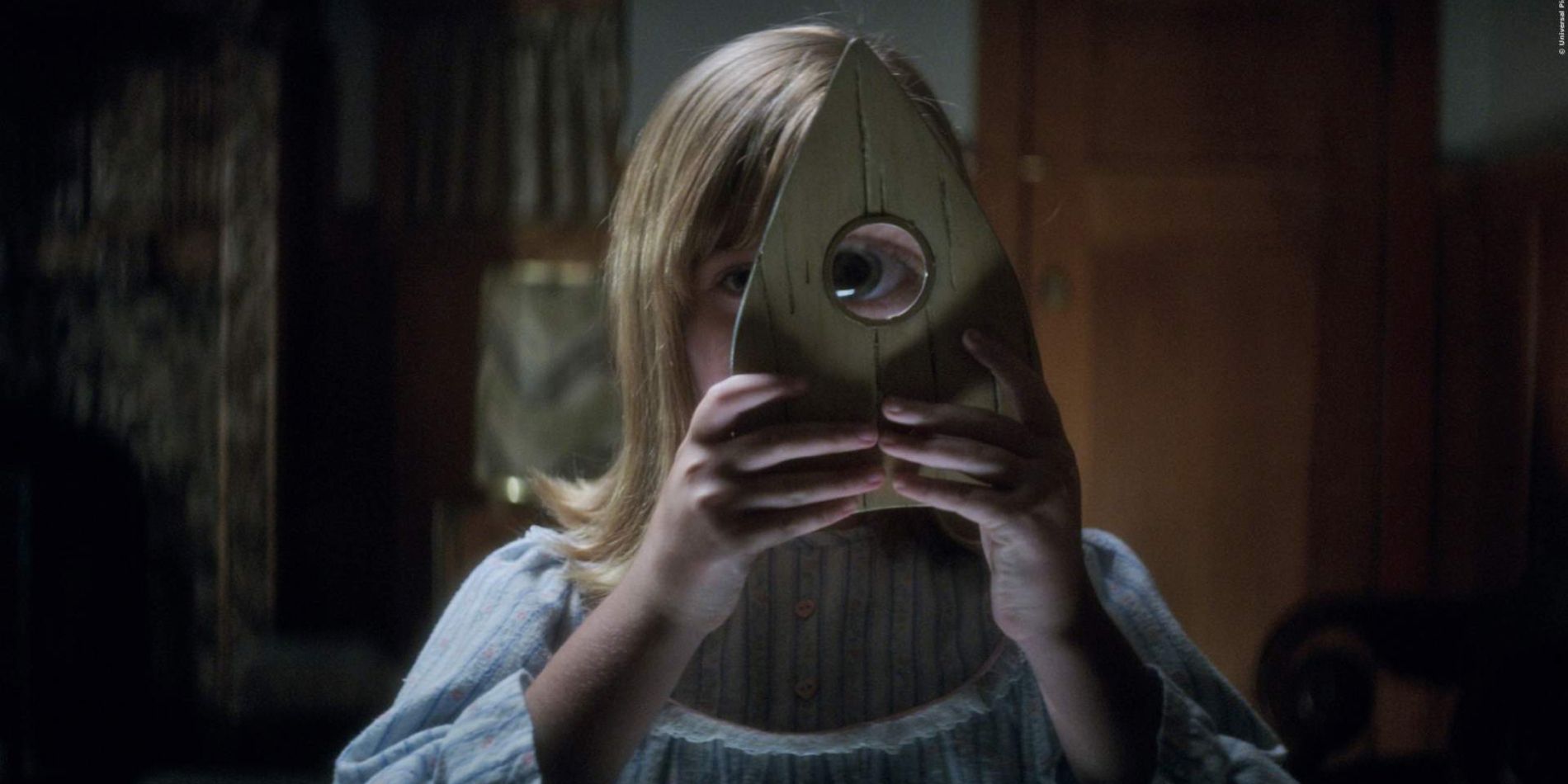 A girl looking through the planchette in Ouija: Origins of Evil