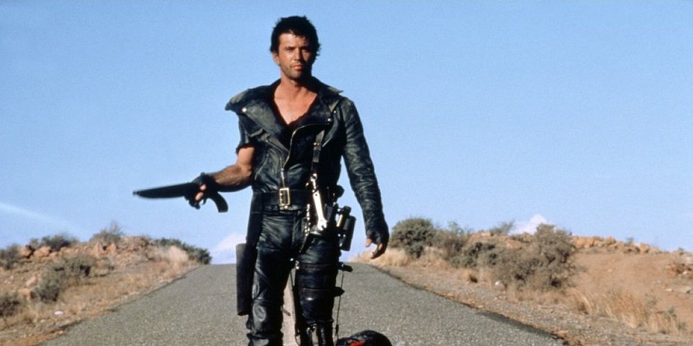 Max Rockatansky walking down a lonely arid road in The Road Warrior