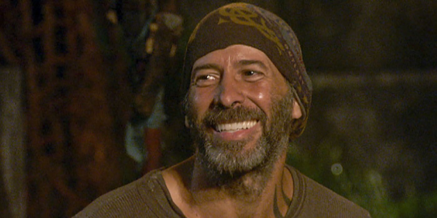 Tony grins at tribal council on Survivor. grinning