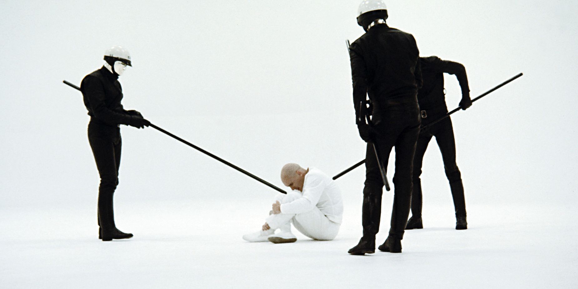 An image of a man sitting in the middle of the floor in THX 1138