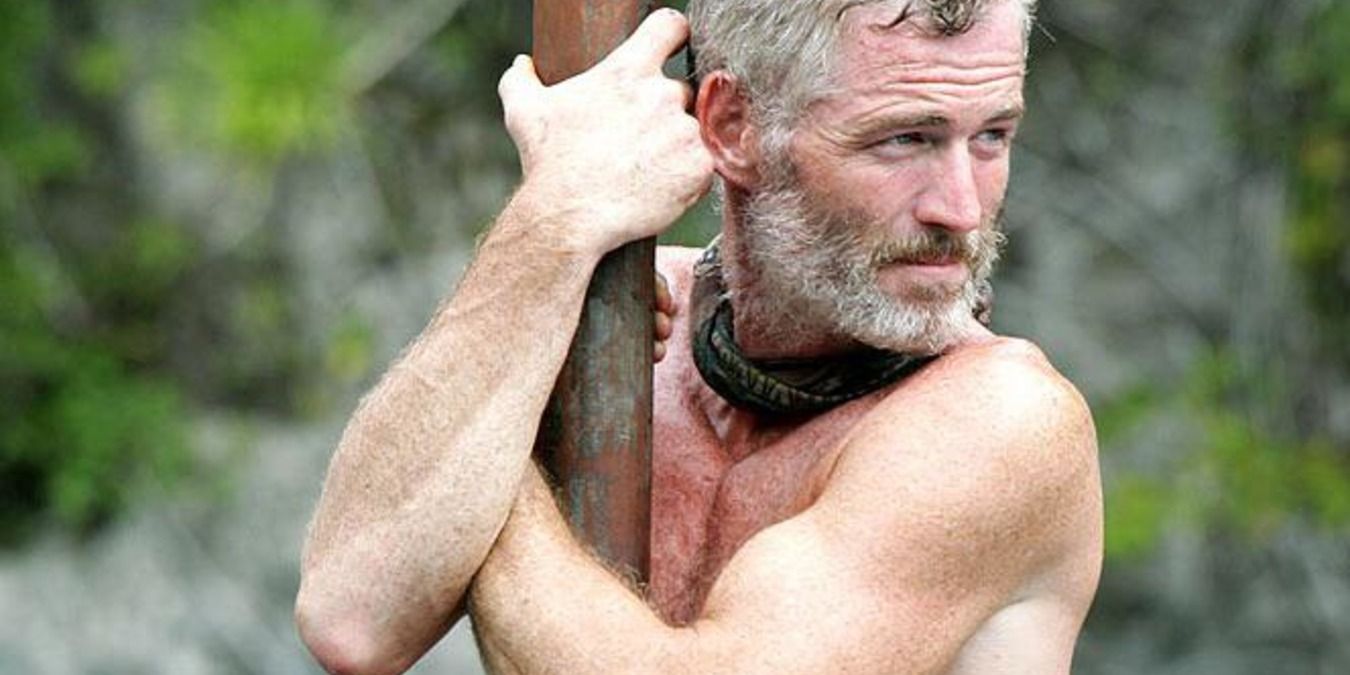 Tom Westman holds onto a pole in Survivor