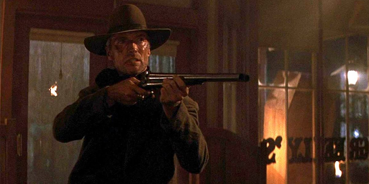 Clint Eastwood aiming a shotgun inside a tavern in Unforgiven