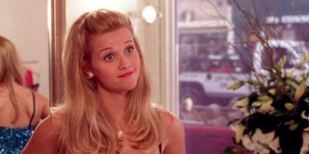 Elle Woods smiles with her back to a mirror in Legally Blonde