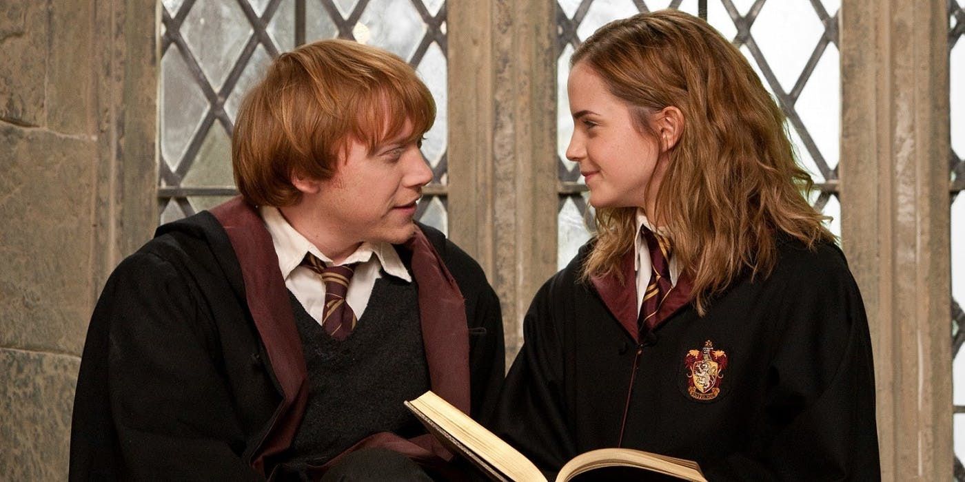 Ron and Hermione smiling at each other as she holds a book in Harry Potter