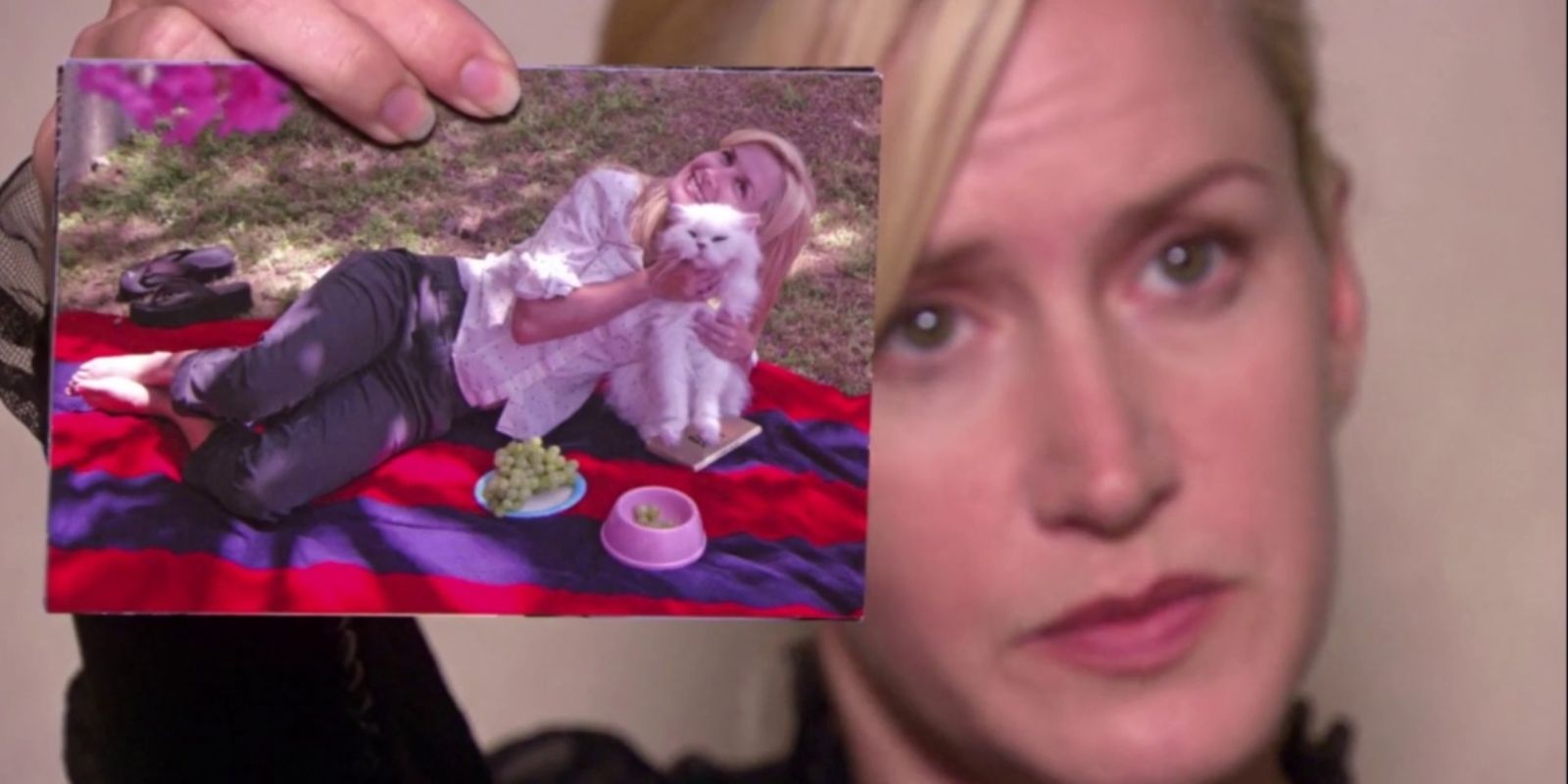 Angela holding up a photo of her and her cat Sprinkles on The Office