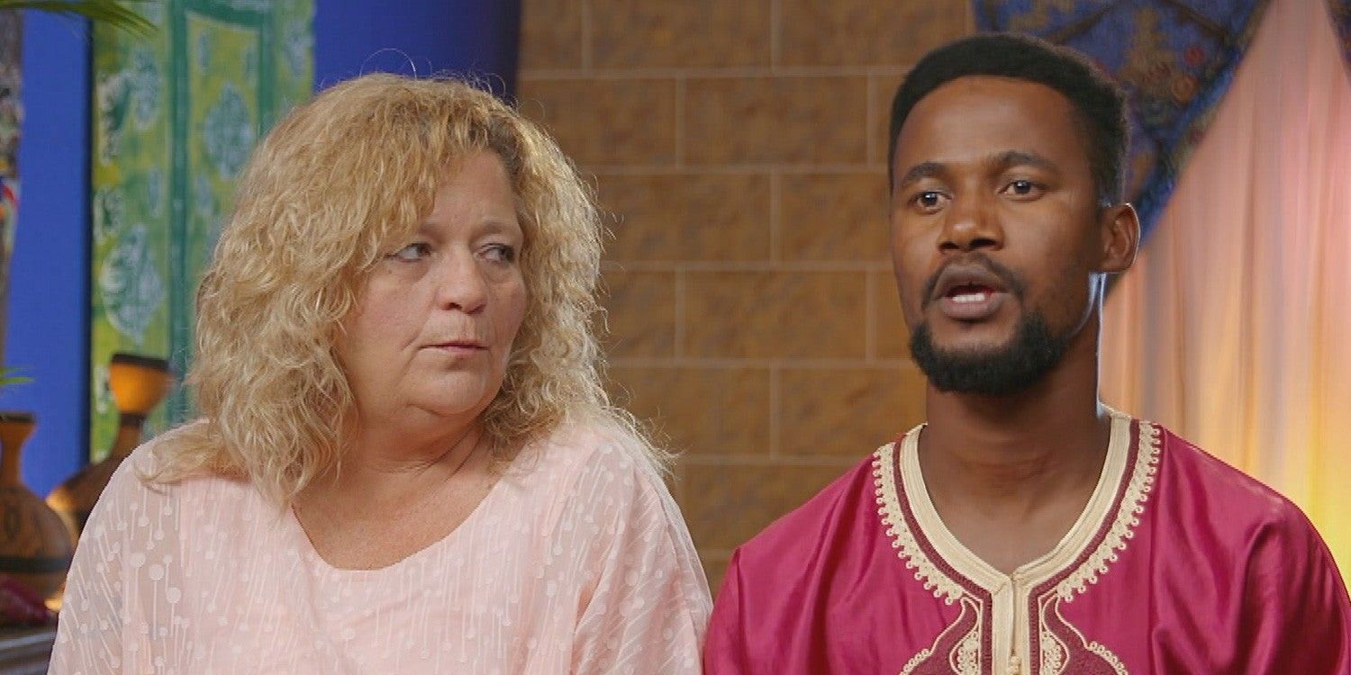 Lisa from 90 Day Fiance in a pink top looking seriously at Usman in a traditional Nigerian outfit.