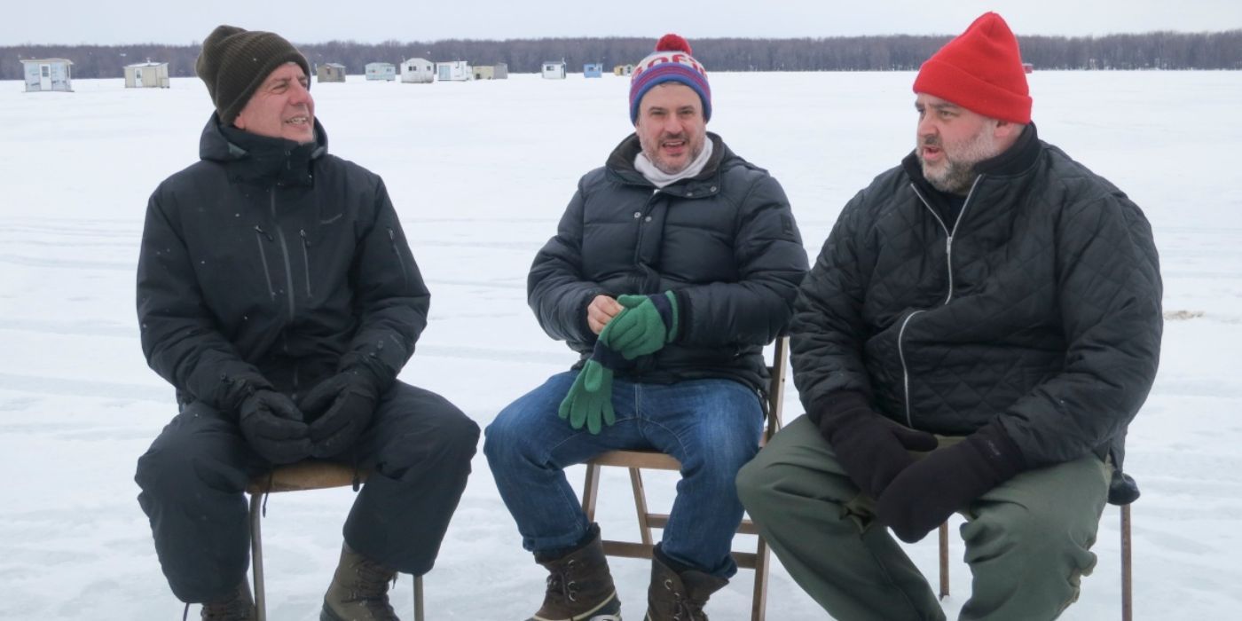 Anthony Bourdain sitting next to Dave McMillan and Fred Morin in the middle of a frozen lake in Parts Unknown.