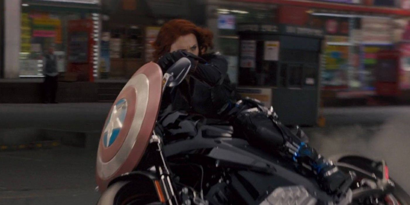 Black Widow rides a bike while carrying Captain America’s shield in Captain America: The Winter Soldier