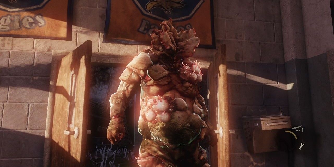 A bloater bursts through a door in The Last of Us