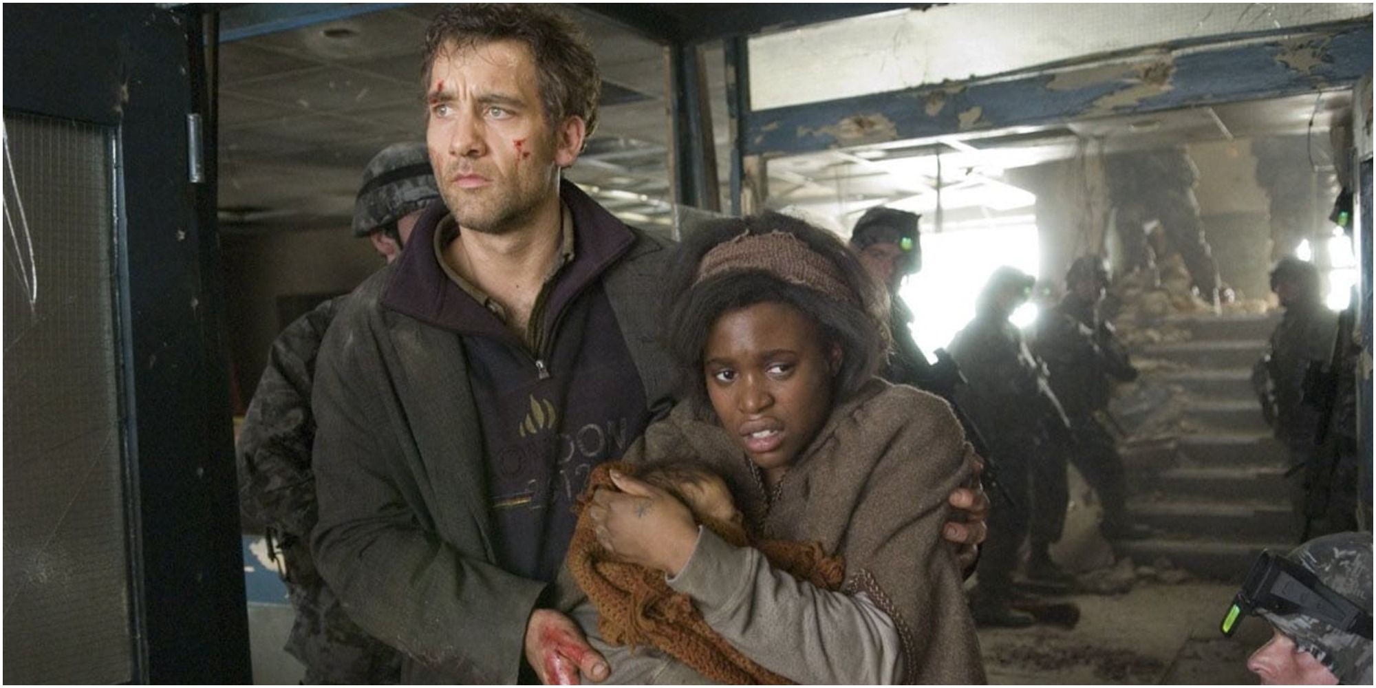 Clare-Hope Ashitey and Clive Owen in Children of Men looking looking miserable surrounded military 