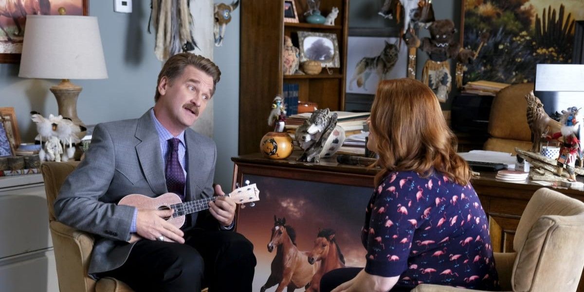 Darryl in a suit and ukelele singing to rebecca