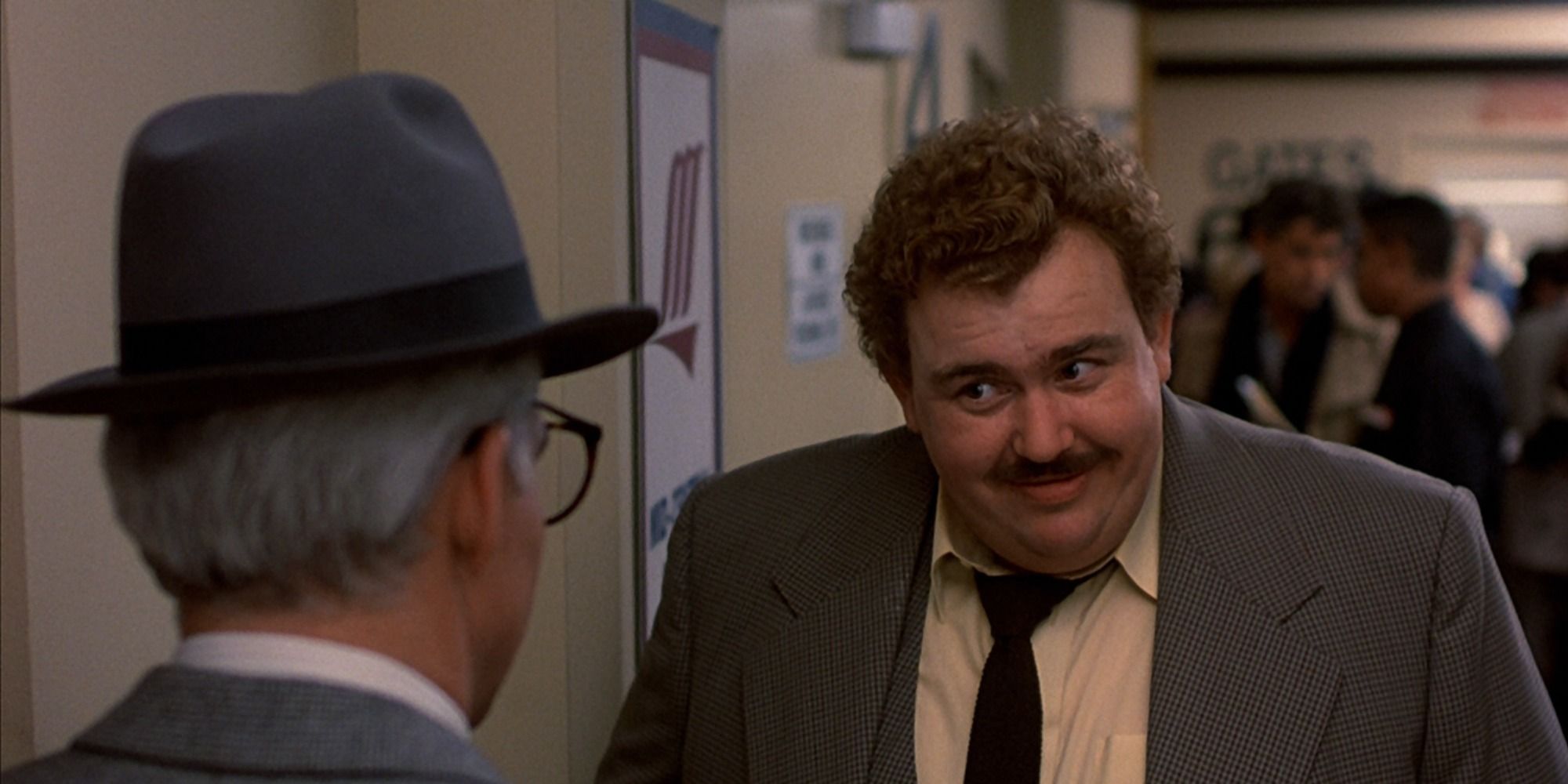 Del talking to Neal at the Wichita airport in Planes, Trains and Automobiles