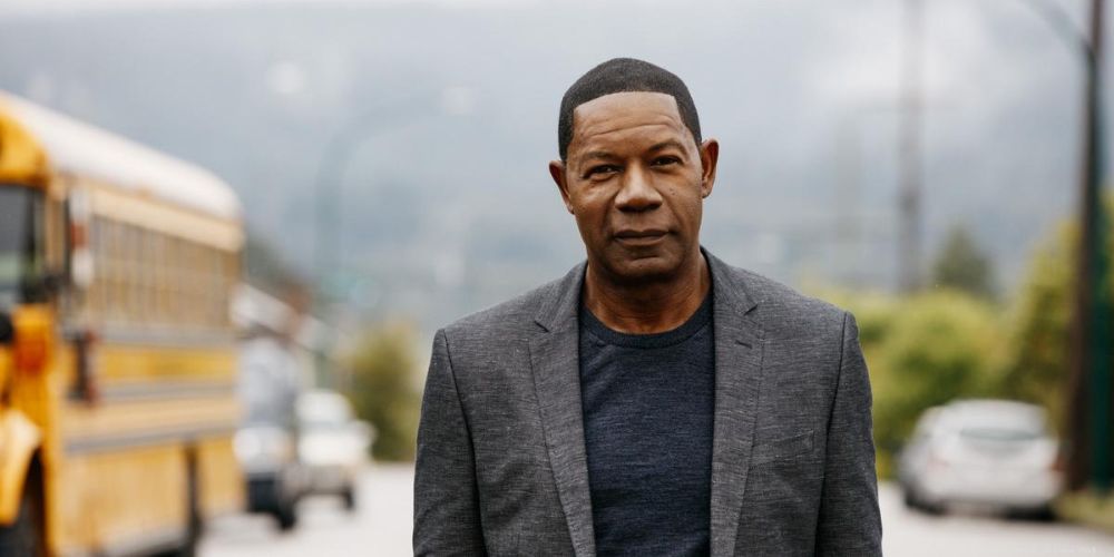 Dennis Haysbert stands next to a school bus in an Allstate commercial