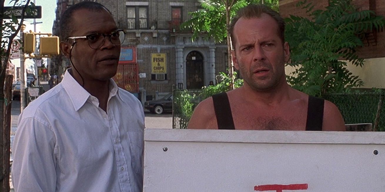 Zeus and John McClane standing side by side in a park in Die Hard With A Vengeance.