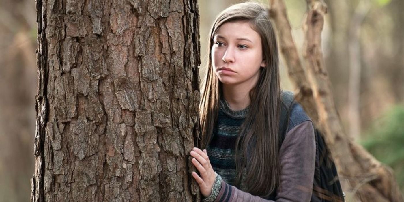 Enid hiding behind a tree in The Walking Dead.