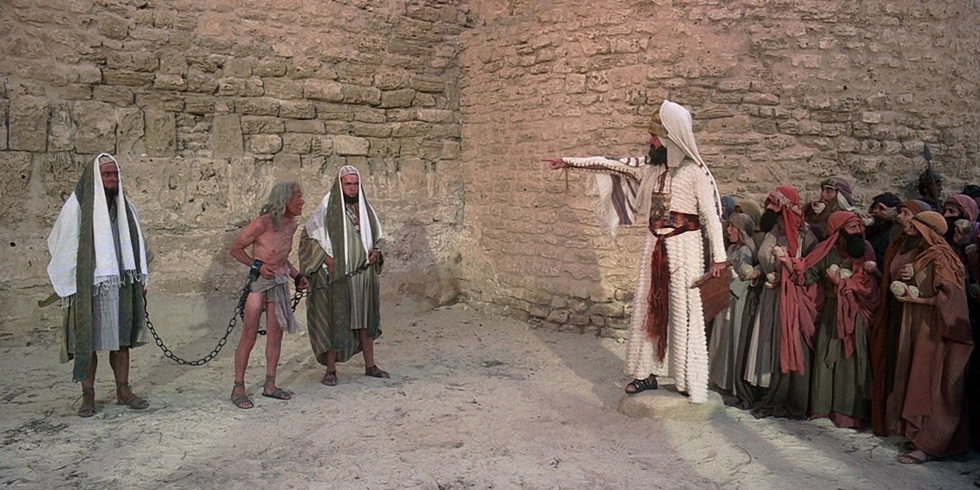 man being held in shackles in the stoning scene in Monty Python's Life of Brian