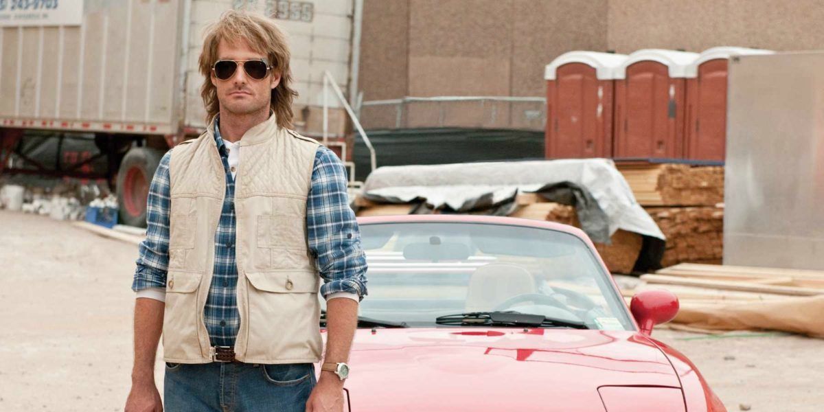 MacGruber stands by a car