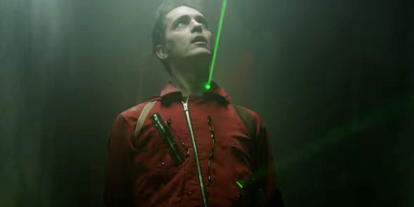 Berlin looking up as a rifle is aimed at him in Money Heist.