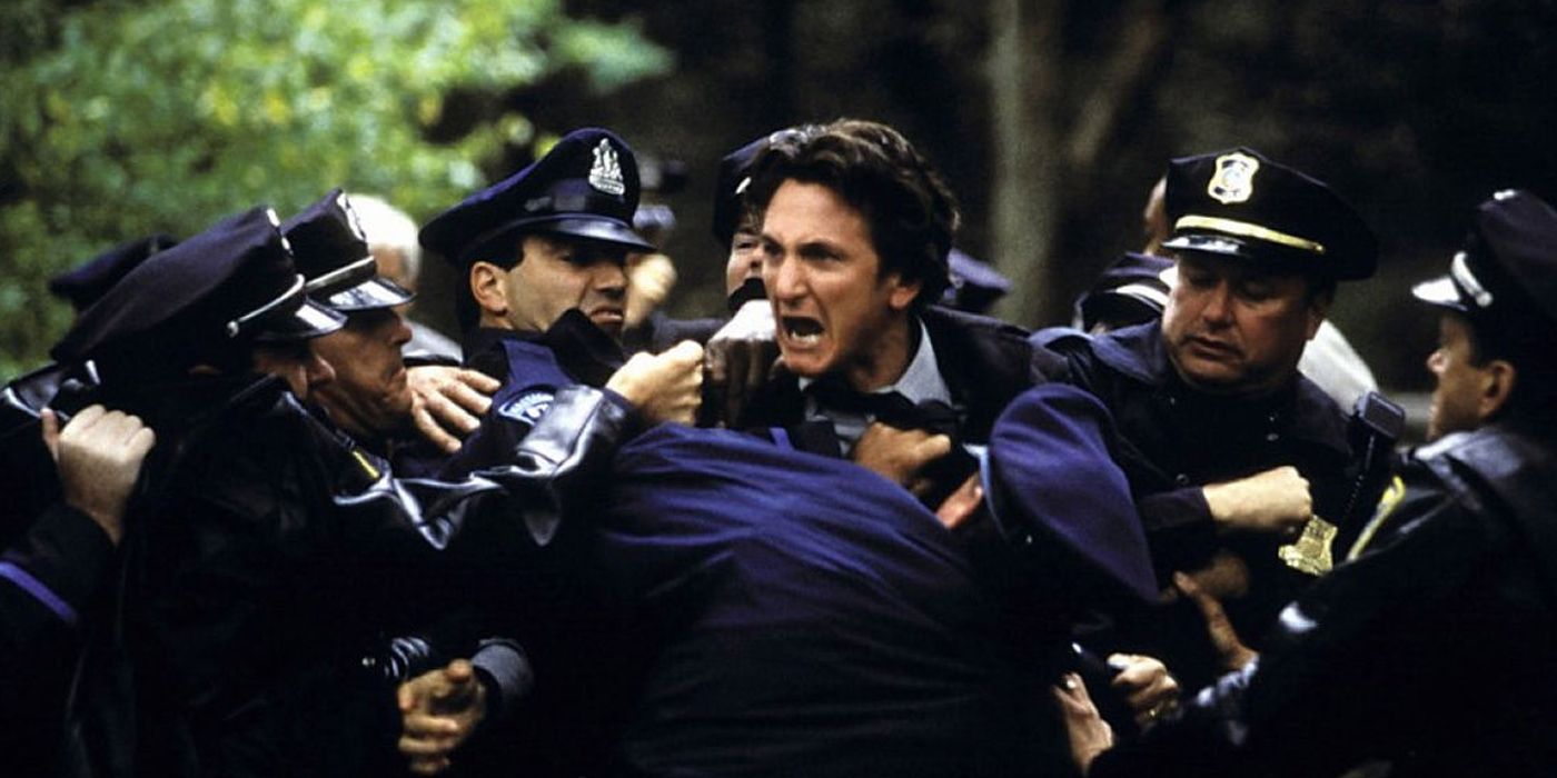 Jimmy cries while being restrained by police officers in Mystic River
