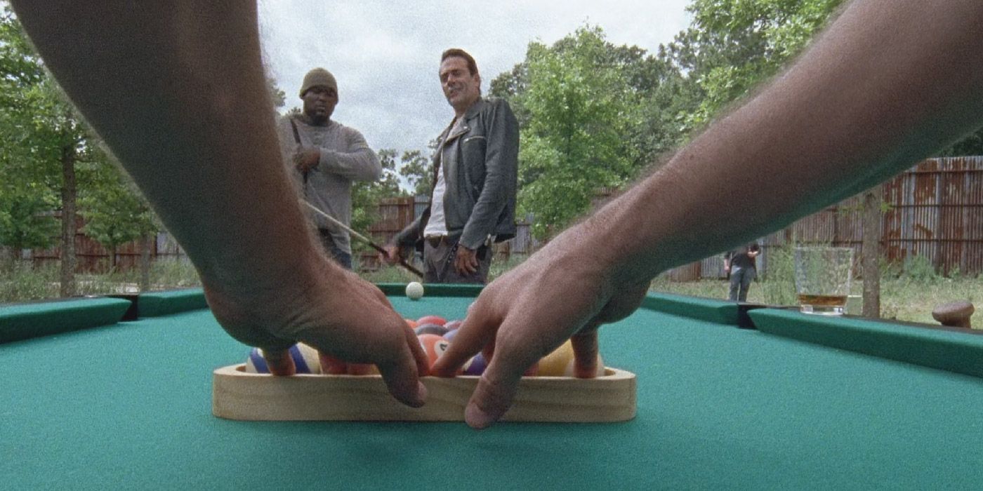 Negan plays pool with Spencer in The Walking Dead.