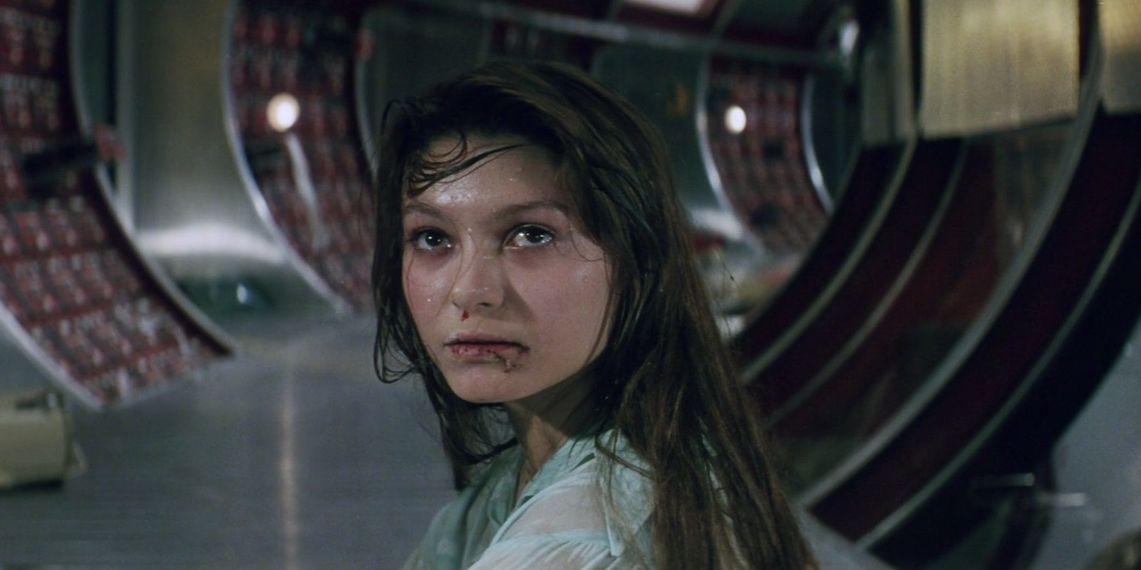 A woman looks behind her in a space station in Solaris.