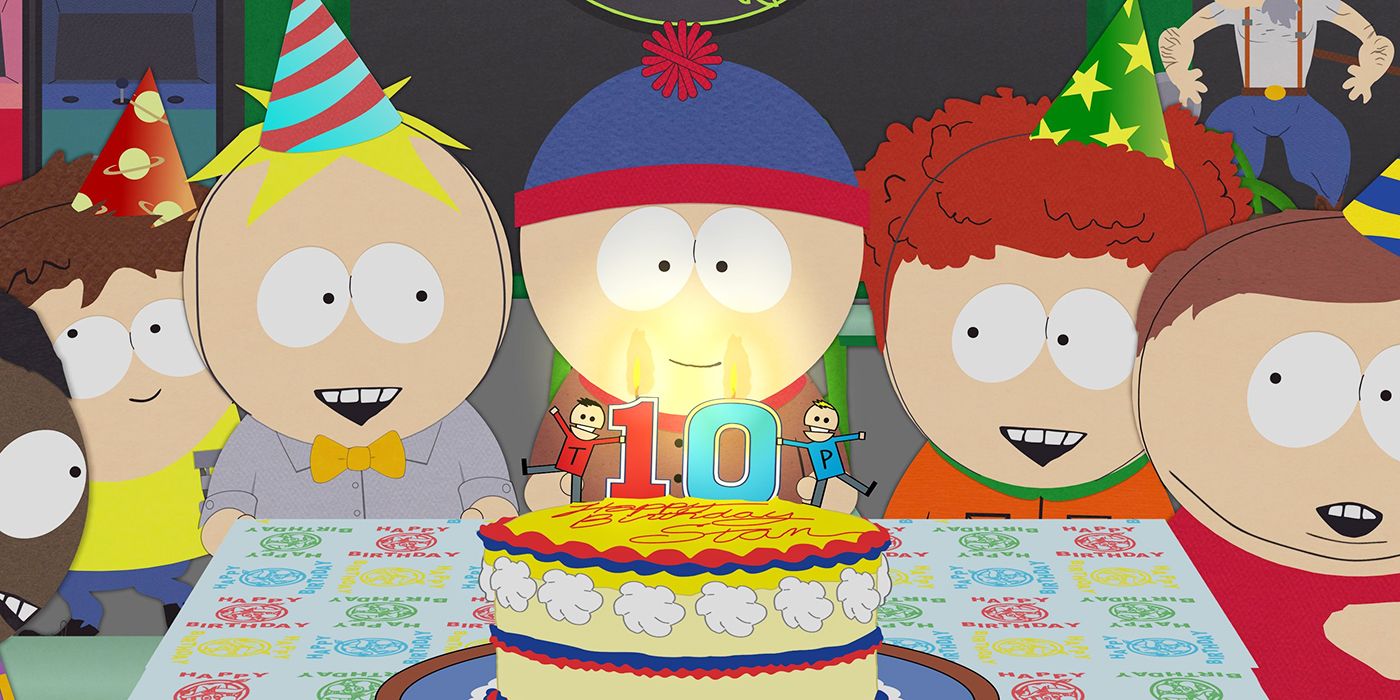 Stan smiles in front of his birthday cake, surrounded by other students in South Park.
