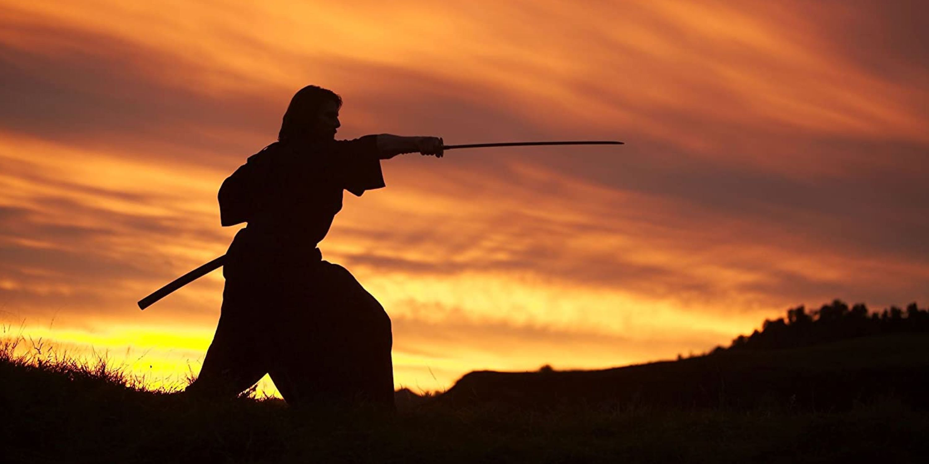 Tom Cruise practicing with a sword at sunset in The Last Samurai