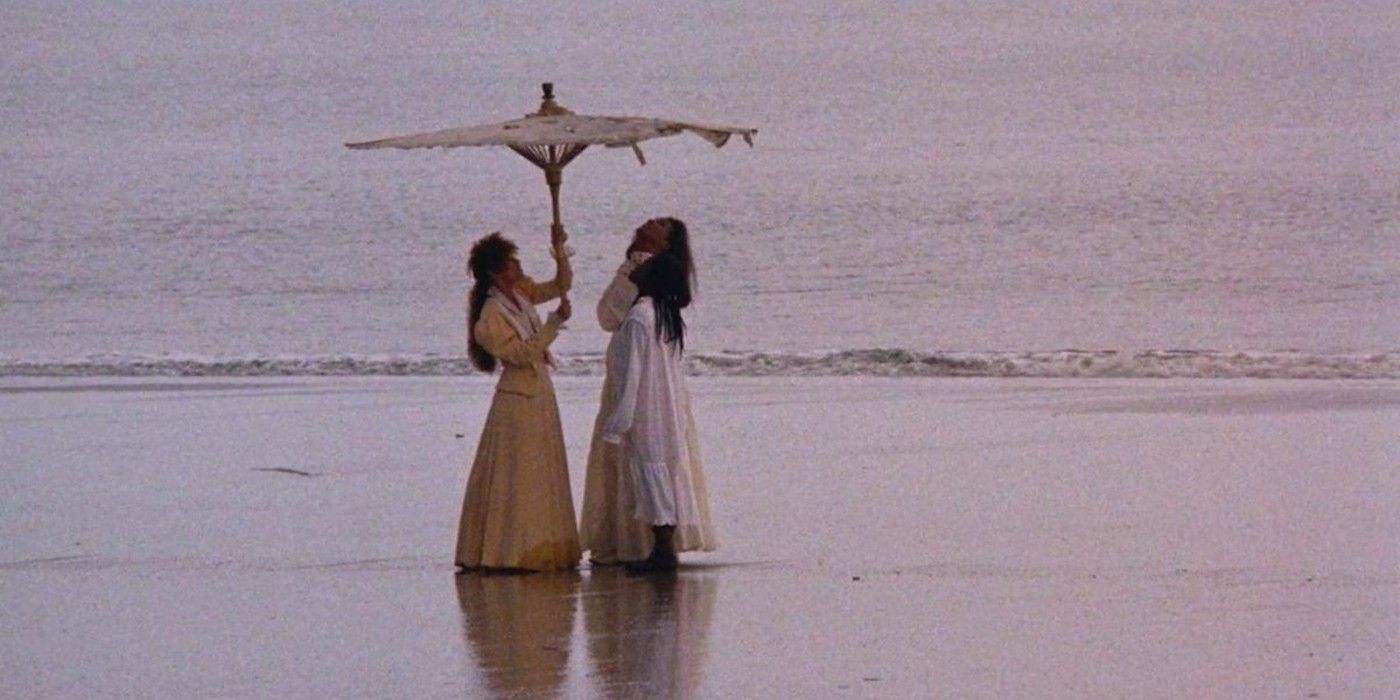 Two women stand under an umbrella in The daughters of the dust