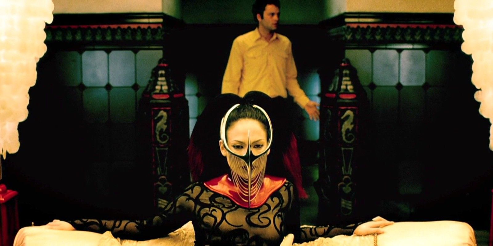 Vince Vaughn standing behind Jennifer Lopez wearing a starnge mask in The Cell