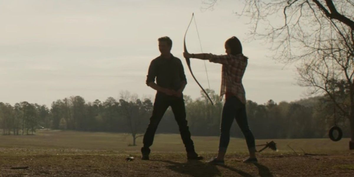 Clint shows his daughter how to shoot an arrow