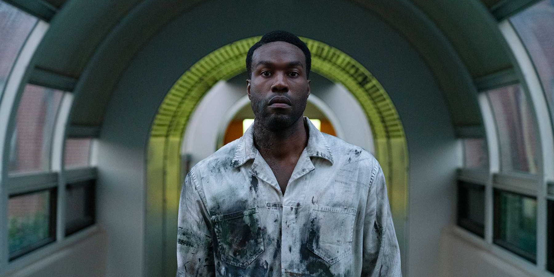 Yahya Abdul-Mateen II wearing paint-covered overalls in Candyman