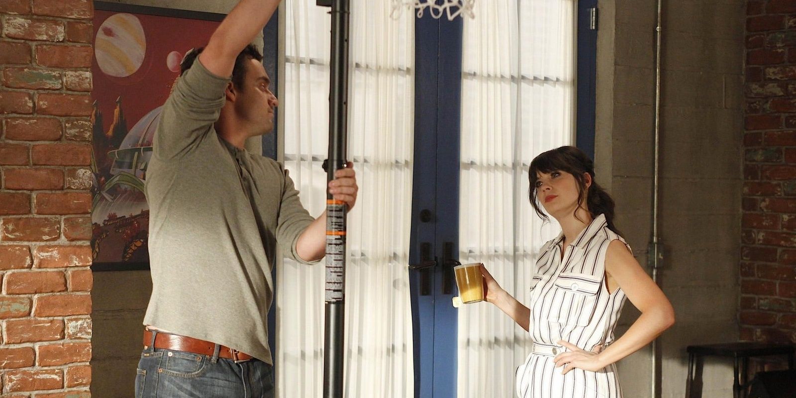 Nick pushing a basketball hoop, and jess standing with a cup of tea