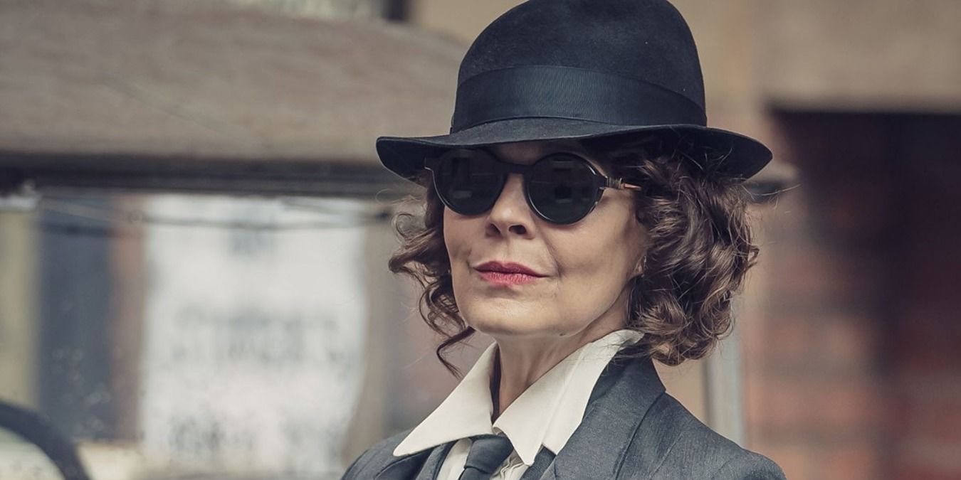 Polly Gray from Peaky Blinders smiling under a hat and sunglasses