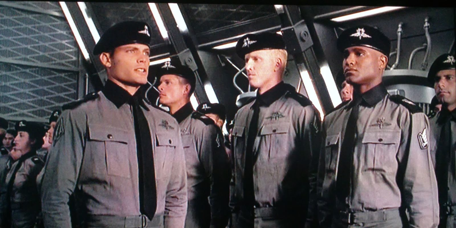 Militant soldiers stand to attention in uniform in Starship Troopers.
