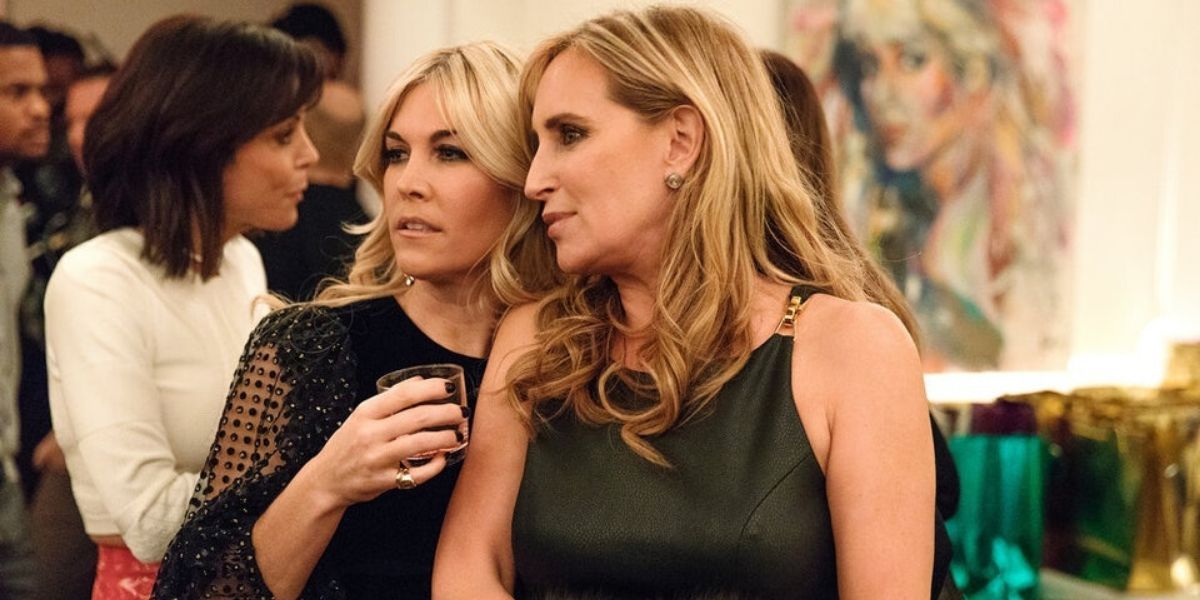 Tinsley and Sonja whispering at a party on RHONY